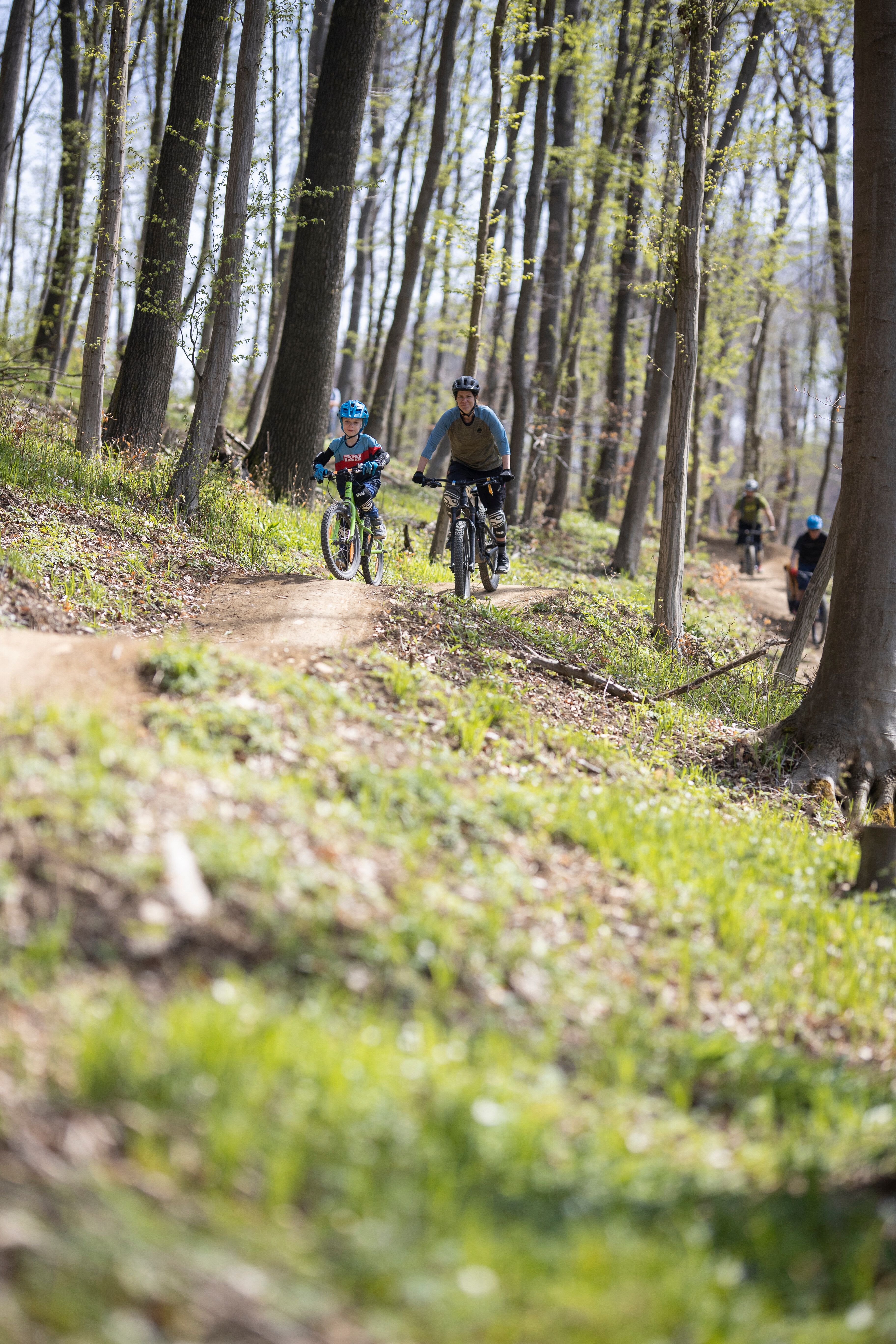Inmitten der grünen Wälder des Wienerwaldes gleiten Radfahrer über kurvenreiche Trails, während die Sonne durch das Blätterdach strahlt. Die frische Luft und das Lachen der Kinder schaffen eine unvergessliche Atmosphäre für Abenteuerlustige und Naturliebhaber. Hier wird der Sommer in den Bergen zum Erlebnis für die ganze Familie.