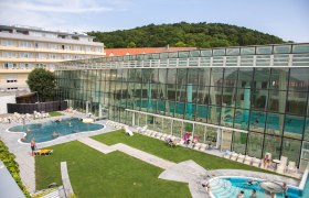 Außenansicht der Römertherme Baden mit Pool und Glasfassade.