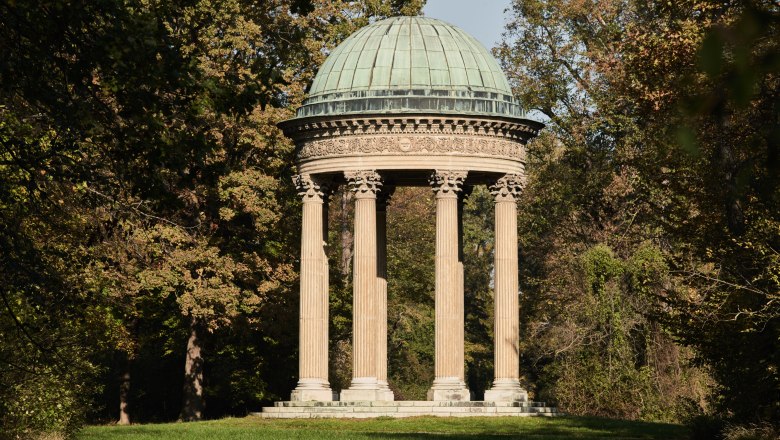 Ein klassizistischer Rundtempel mit S&auml;ulen und Kuppel im Gr&uuml;nen.